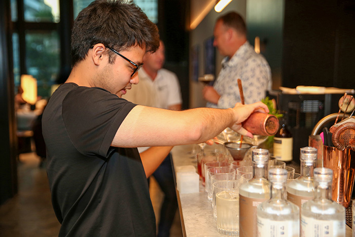 Profile shot of a bartender pouring a cocktail.